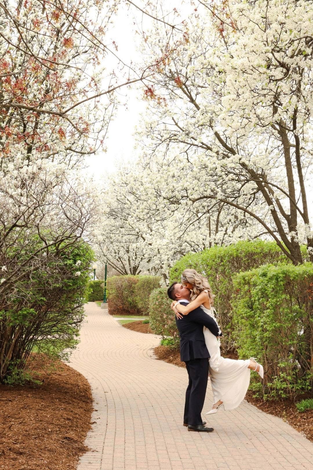A couple embracing on a blossom-lined path